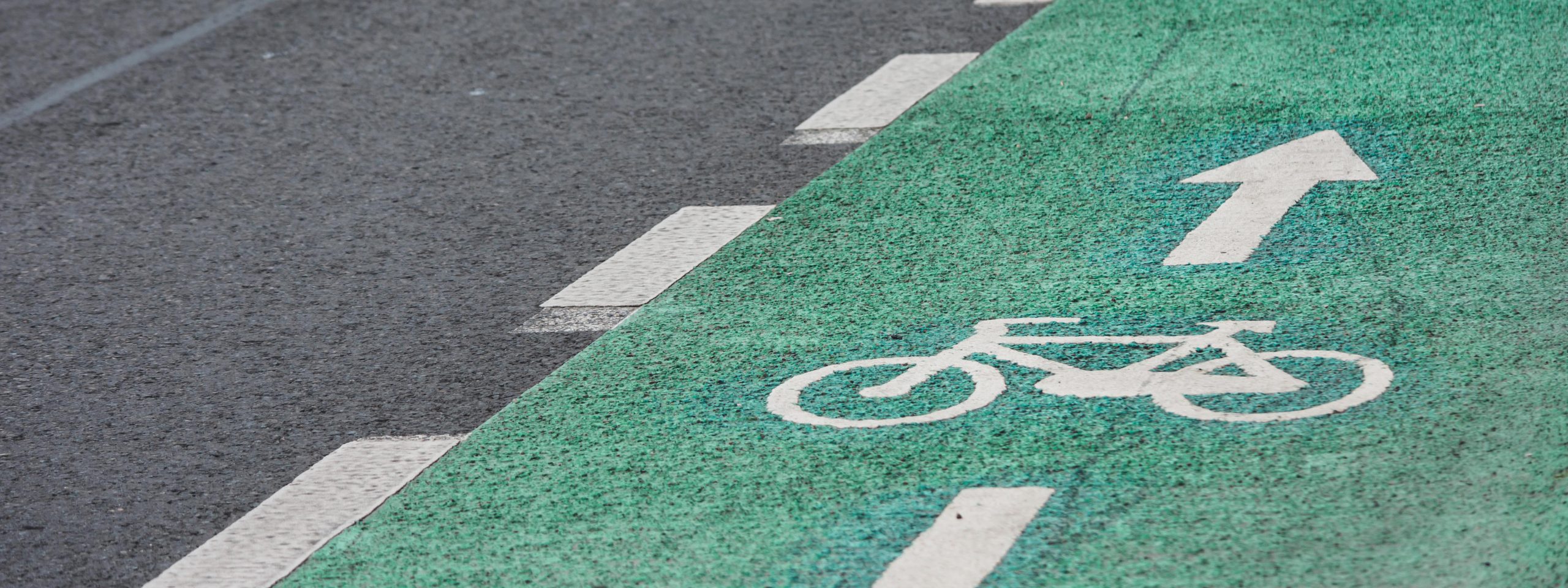 Grüner Fahrradweg mit Fahrradzeichen und Pfeil nach vorn